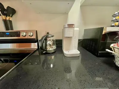 a kitchen counter with a coffee maker and a toaster at AK Stay in Abbotsford