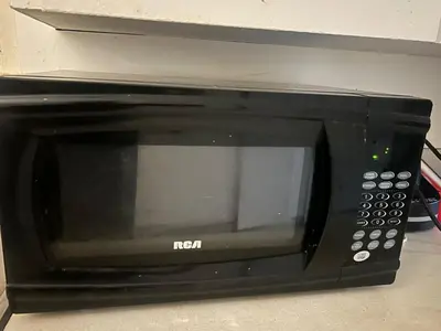 a black microwave oven sitting on top of a counter at Airport Vancouver Private Rooms - Transit at Doorstep, Free Parking & Fast Wi-Fi in Vancouver