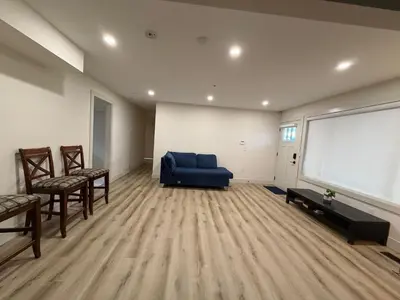 a living room with a blue couch and a large screen at Downtown Vancouver Rooms - Walk to SkyTrain & BC Place, Free Parking & Fast Wi-Fi in Vancouver