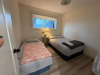 two beds in a small room with a window at Downtown Vancouver Rooms - Walk to SkyTrain & BC Place, Free Parking & Fast Wi-Fi in Vancouver