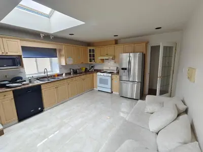 a large kitchen with a couch and a refrigerator at Vancouver Private Rooms - Free Parking, Fast Wi-Fi, Easy Transit - 15 mins Downtown & 11 mins Airport in Vancouver