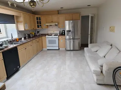 a large kitchen with a couch and a stove and refrigerator at Vancouver Private Rooms - Free Parking, Fast Wi-Fi, Easy Transit - 15 mins Downtown & 11 mins Airport in Vancouver