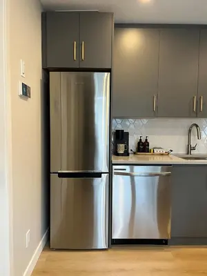 a kitchen with a stainless steel refrigerator and a sink at Pet-friendly Walk-Up Condo with Pool & Hot tub! in Canmore