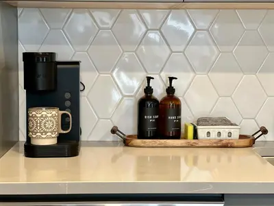 a kitchen counter with two bottles of wine on a tray at Pet-friendly Walk-Up Condo with Pool & Hot tub! in Canmore