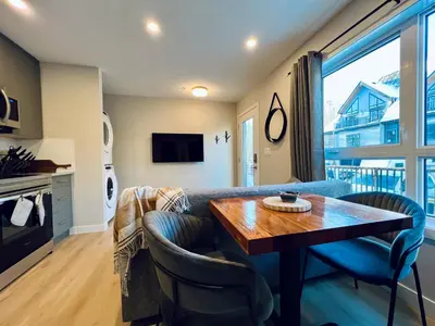 a living room with a table and a couch at Pet-friendly Walk-Up Condo with Pool & Hot tub! in Canmore