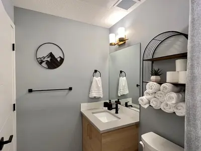 a bathroom with a sink and a mirror at Pet-friendly Walk-Up Condo with Pool & Hot tub! in Canmore