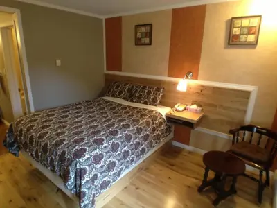 a bedroom with a bed and a table and a chair at Galaxy Motel in St. Paul