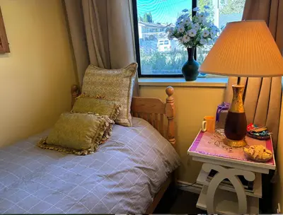 a bedroom with a bed and a table with a lamp at Sweet Home in Aldergrove