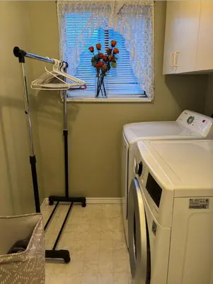 a laundry room with a washing machine and a window at Sweet Home in Aldergrove