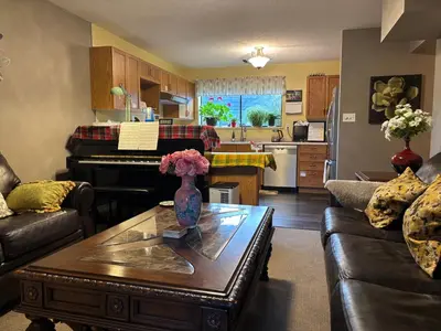 a living room with a table and a piano at Sweet Home in Aldergrove