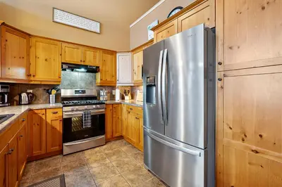 a kitchen with wooden cabinets and a stainless steel refrigerator at Blackrock 6 in Big White