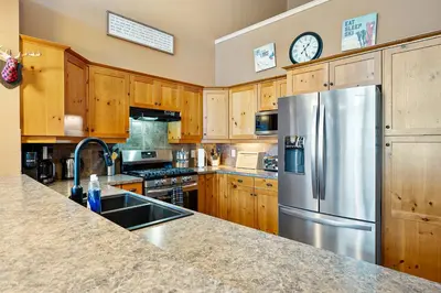 a kitchen with wooden cabinets and a stainless steel refrigerator at Blackrock 6 in Big White