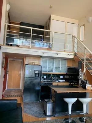 a kitchen with a stainless steel refrigerator and a staircase at 933 seymour at vancouver downtown in Vancouver