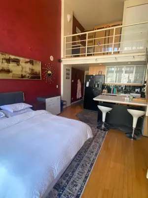 a bedroom with a large bed and a kitchen at 933 seymour at vancouver downtown in Vancouver