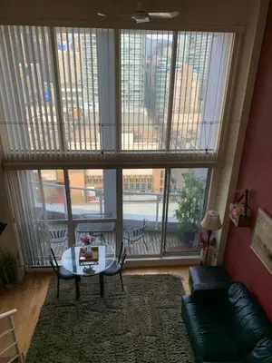 a living room with a table and a large window at 933 seymour at vancouver downtown in Vancouver