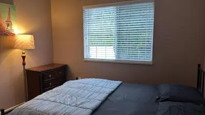 a bedroom with a bed with a window and a lamp at Surrey- Delta Budget Guest House - Private Rooms & Suites, Free Parking & Fast Wi-Fi in Surrey