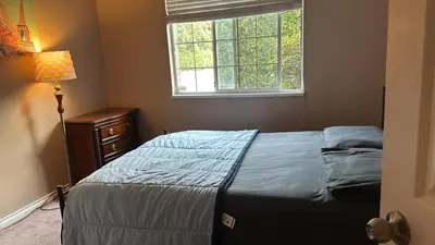 a bedroom with a bed and a window at Surrey- Delta Budget Guest House - Private Rooms & Suites, Free Parking & Fast Wi-Fi in Surrey