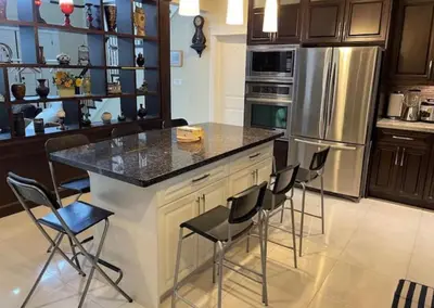a kitchen with a island with chairs and a refrigerator at Vancouver Burnaby Villa 44 in Burnaby