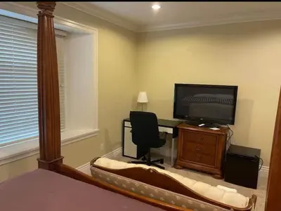 a bedroom with a bed and a desk with a television at Vancouver Burnaby Villa 44 in Burnaby