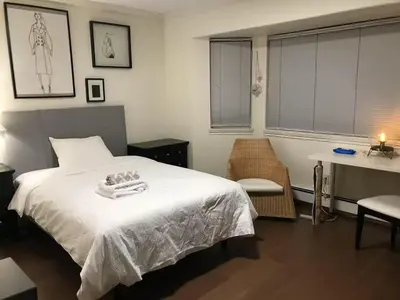a bedroom with a white bed and a table and a desk at Vancouver Richmond Villa43 in Richmond