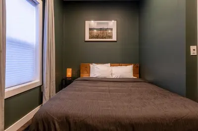a bedroom with a large bed with a window at Peaks & Pines by Fernie Central Reservations in Fernie