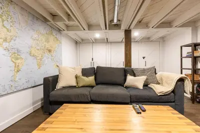 a living room with a black couch and a map at Peaks & Pines by Fernie Central Reservations in Fernie