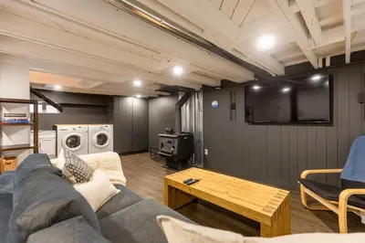 a living room with a couch and a tv at Peaks & Pines by Fernie Central Reservations in Fernie