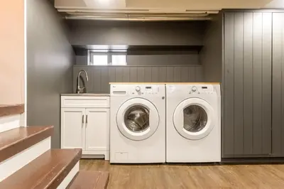 a laundry room with two washing machines and a sink at Peaks & Pines by Fernie Central Reservations in Fernie