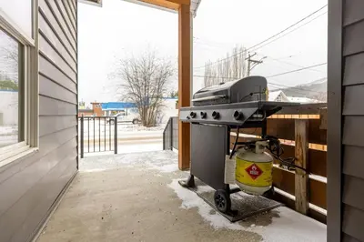 a grill on a porch with snow on the ground at Peaks & Pines by Fernie Central Reservations in Fernie