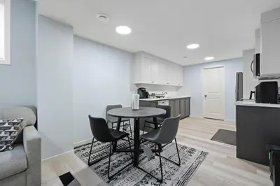 a kitchen with a table and chairs in a room at Cozy 2 Bedroom Private Basement Suite SW Calgary in Calgary