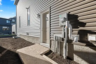 a building with a door and a water meter on it at Cozy 2 Bedroom Private Basement Suite SW Calgary in Calgary