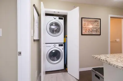 a laundry room with a washer and dryer at Modern Central Location with Pool Sauna & Jacuzzi in Vancouver