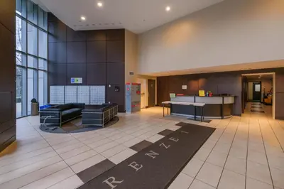 a lobby with a couch and a desk in a building at Modern Central Location with Pool Sauna & Jacuzzi in Vancouver