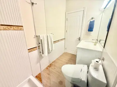 a white bathroom with a toilet and a sink at Private Guest Suite, Two Parking Spaces in Maple Ridge District Municipality