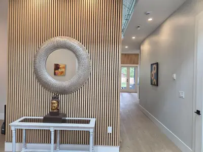 a hallway with a round mirror on a striped wall at Luxury Suite in New Villa in Surrey
