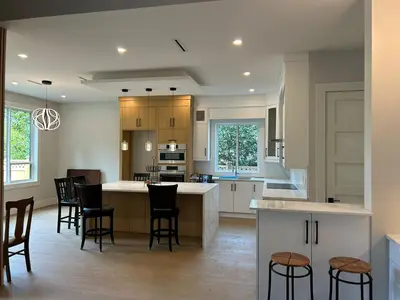 a kitchen with a island and bar stools at Luxury Suite in New Villa in Surrey