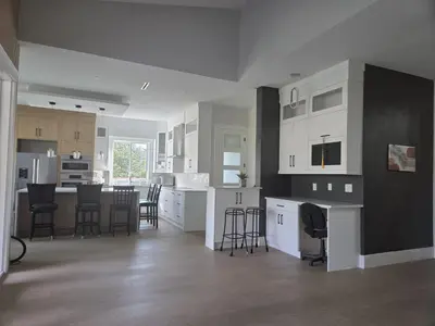 a kitchen with white cabinets and a table and chairs at Luxury Suite in New Villa in Surrey