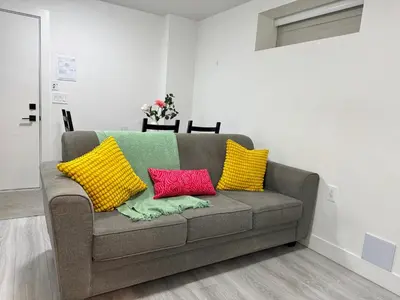 a couch with four colorful pillows on it in a room at Comfort 2 BR Vancouver! in Vancouver