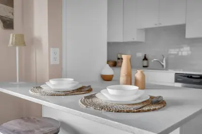 a kitchen counter with two plates and bowls on it at 2B 17 Ave King Suite in Calgary