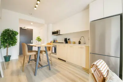 a kitchen with a table and a stainless steel refrigerator at 1506 First and Park in Calgary