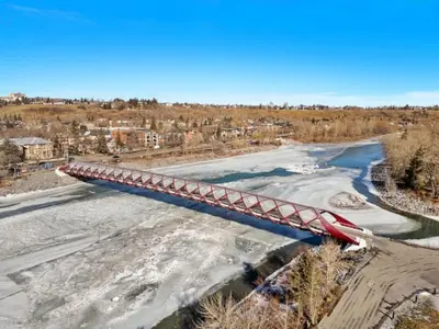 a red bridge over a river with snow at 1506 First and Park in Calgary