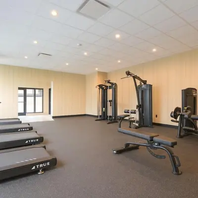 a gym with several treadmills and exercise machines at 1506 First and Park in Calgary