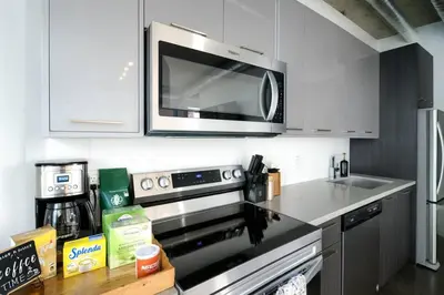 a kitchen with a microwave above a stove at Cozy Downtown Retreat with Stunning River Views in Calgary