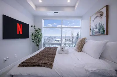a bedroom with a large white bed with a large window at 418 Frontier in Calgary