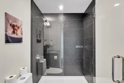 a bathroom with a toilet and a glass shower at 1409 Guardian South in Calgary