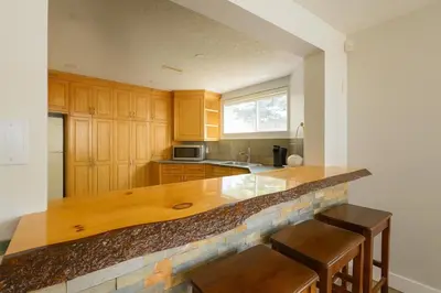 a kitchen with wooden cabinets and a counter with stools at Shiraz Place in Calgary