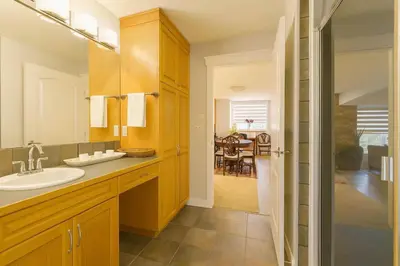 a bathroom with a sink and a mirror and a table at Shiraz Place in Calgary
