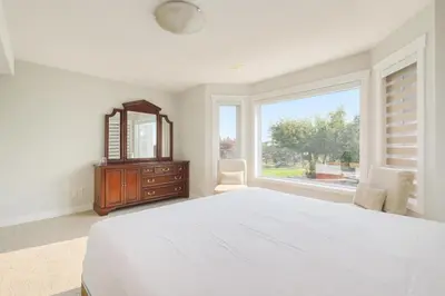a bedroom with a bed and a mirror and a window at Shiraz Place in Calgary