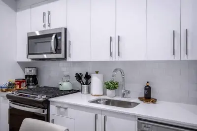 a kitchen with white cabinets and a sink and a microwave at 431 Frontier in Calgary