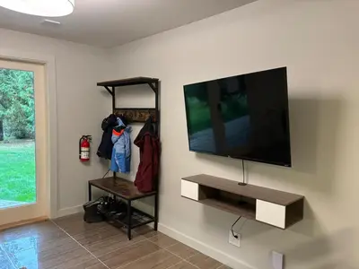 a living room with a flat screen tv on a wall at Coastal Drift Sooke in Sooke